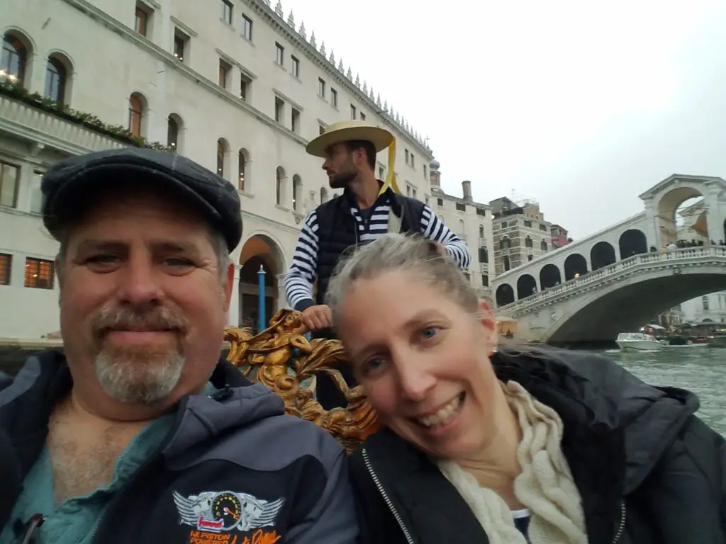 couple on a gonola ride in front of a Venice bridge