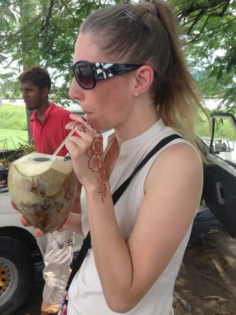 lady drinking a coconut with a straw