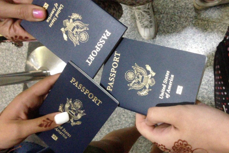 hands holding 3 passports