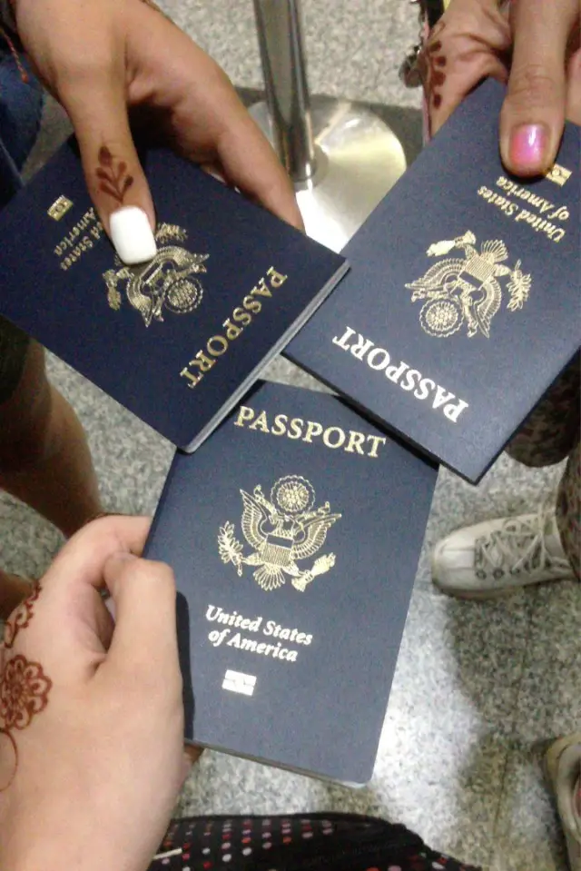 3 people holding passports together