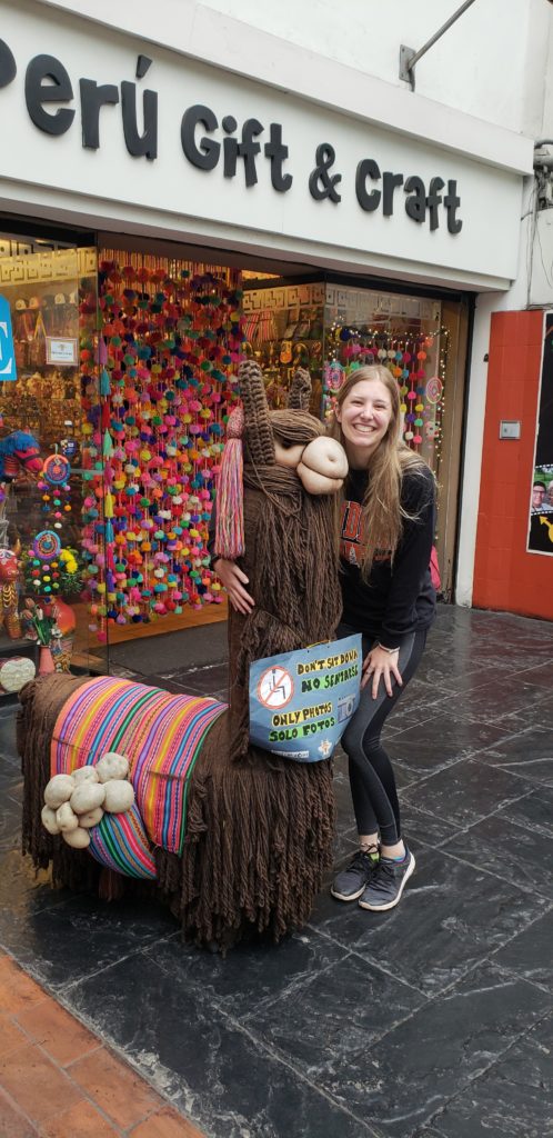 standing with a fake llama outside a souvenir shop