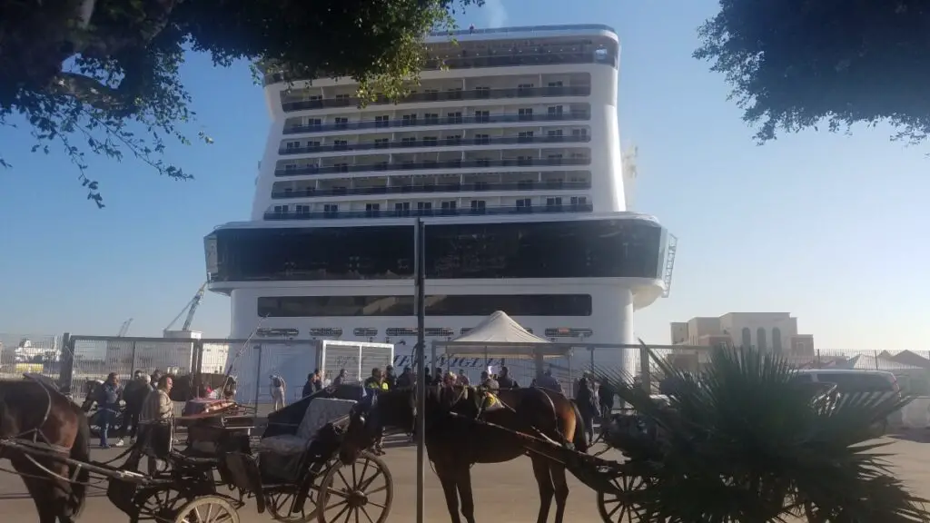 back view of the ship MSC Meriviglia docked for one day in Palermo Sicily with horse and buggy ready for tours