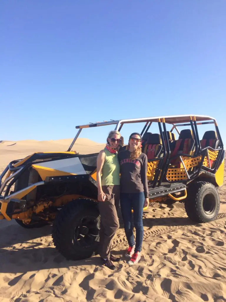 Posing with our dune buggy before sand boarding in Huacachina, Peru