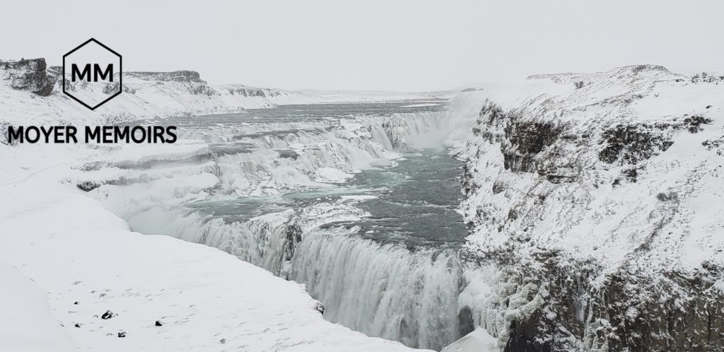 huge waterfall surrounded by snow in Iceland