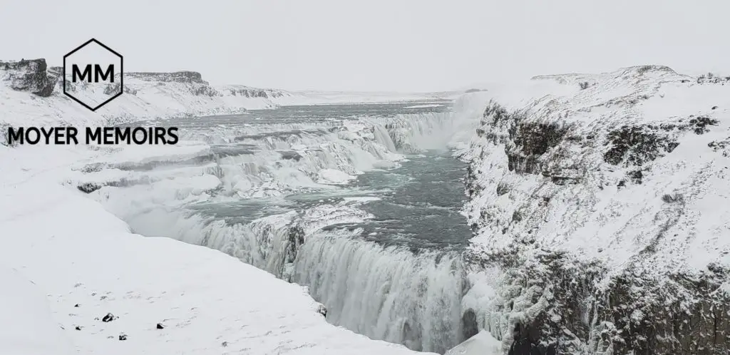 huge waterfall surrounded by snow in Iceland