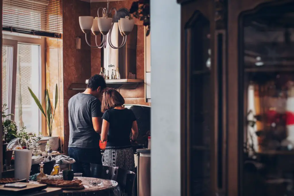 couple cooking food in kitchen