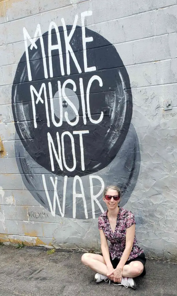 seated in front of Make Music not War one of the wall murals in Nashville TN