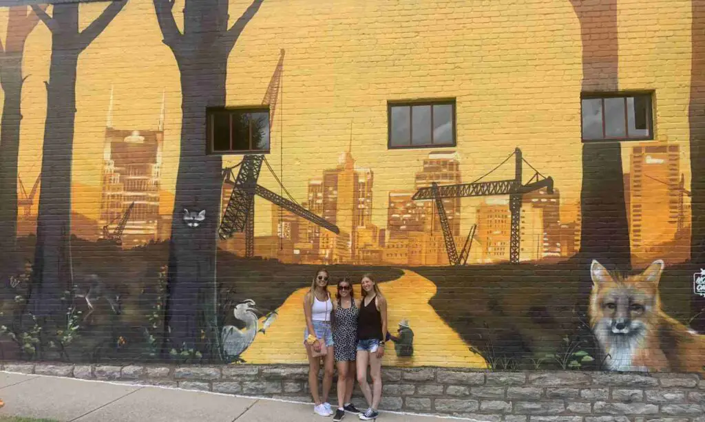 three girls in front of the yellow fox street art: one of the best Nashville murals