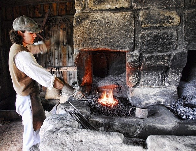 blacksmith working over hot coals