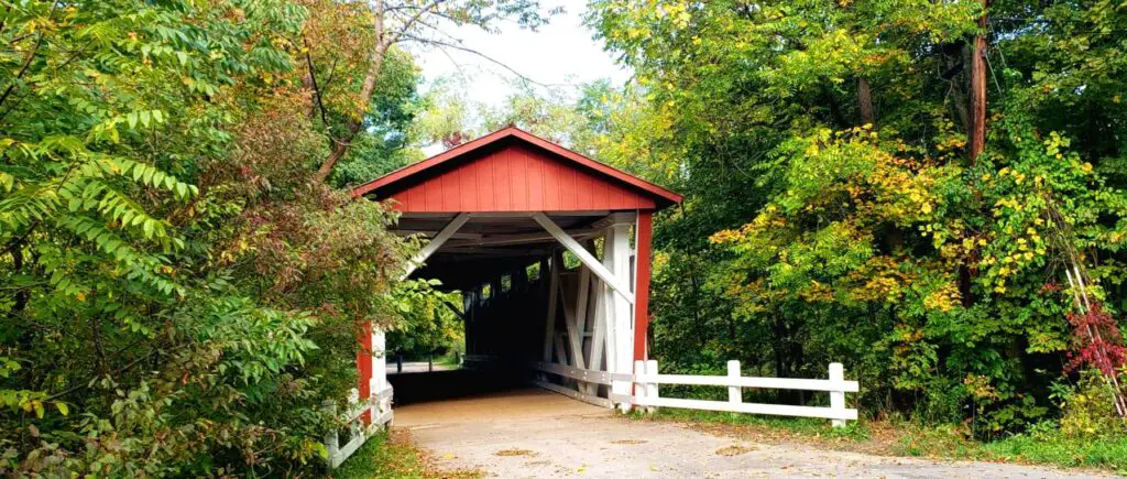 red covered bridge surrounded by green trees in cuyahoga national park