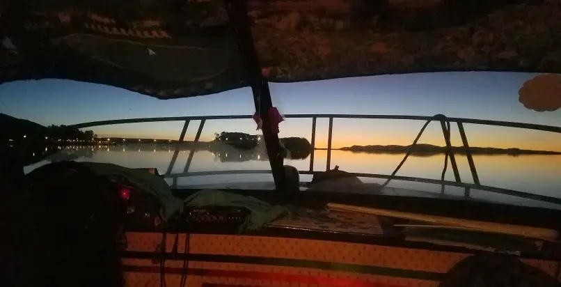 view of sunrise from a boat on lake titicaca in peru
