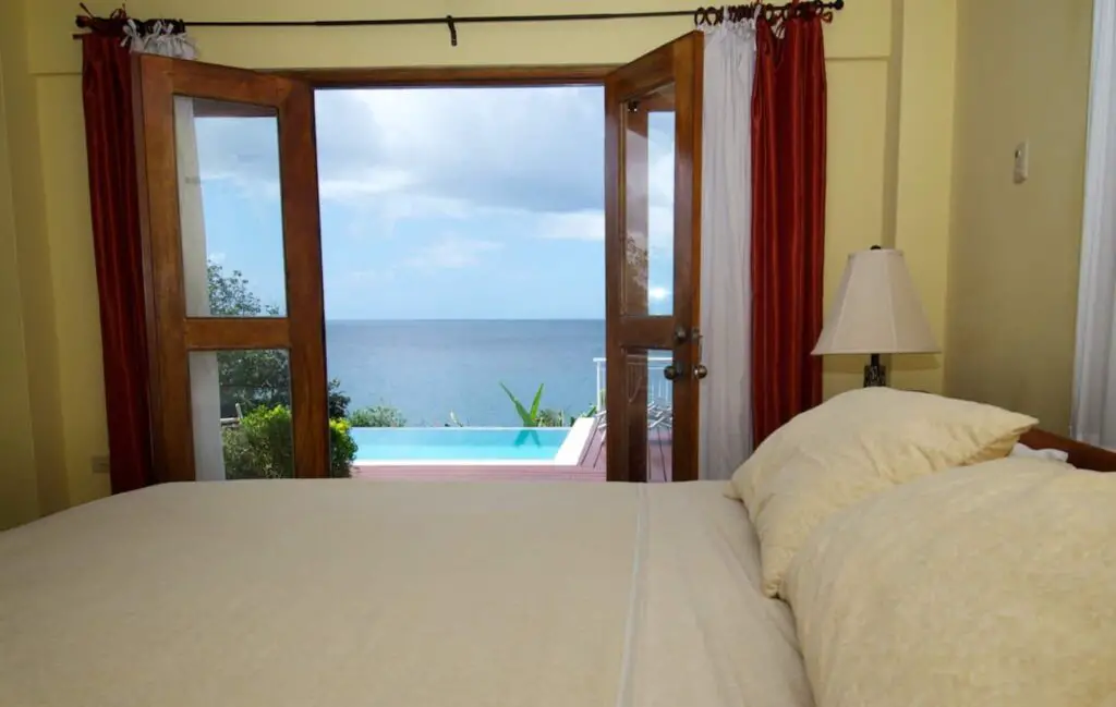 bedroom overlooking the pool and the sea at Mot Mot Luxury Lodge-bedroom - guest houses in Tobago