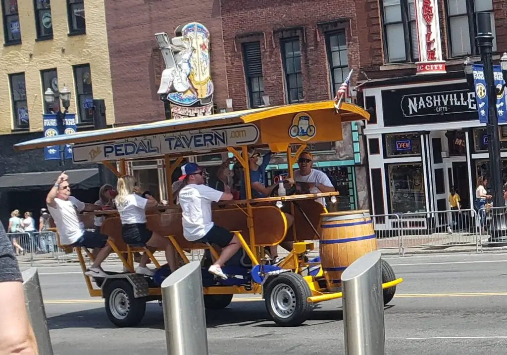 group of people seating on Pedal Bar going down the street in Nashville