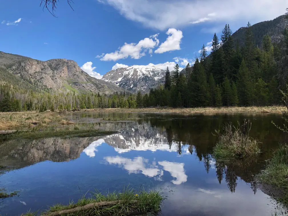 reflection of clouds in a lake surrounded by mountains at Rocky Mountain National Park Relaxing US trip idea