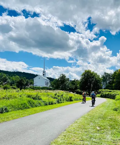 biking past a church on a grownup getaway in Stowe Vermont