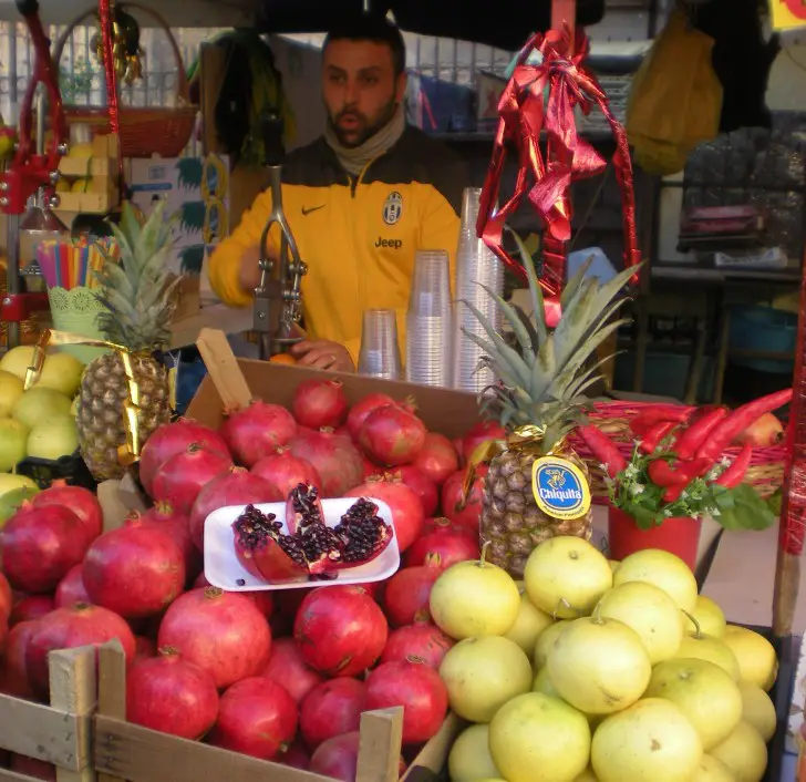 man selling Pomegranites at the Palermo Market