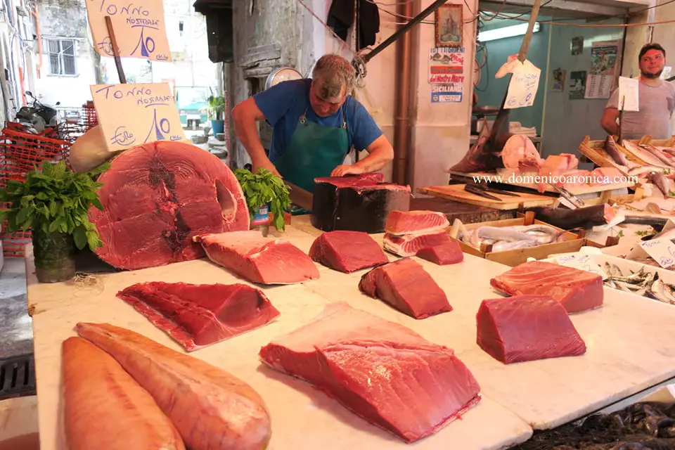 man cutting large slabs of Red Tuna at Palermo Sicily food markets