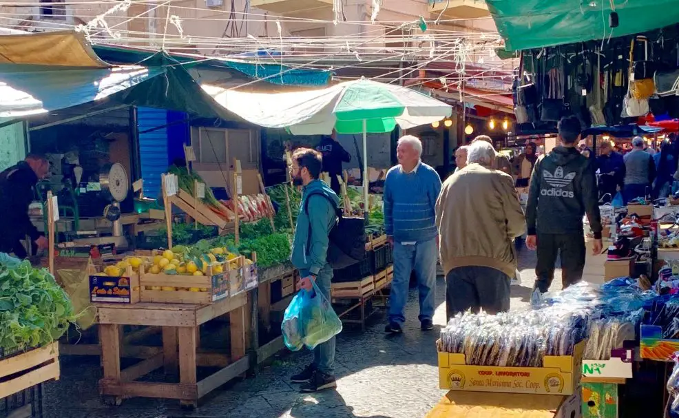 colorful stalls and vendors selling lots of food at the Palermo street food market