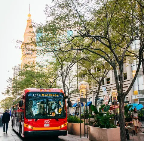 red free shuttle going along city street on Denver