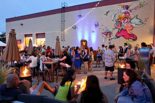 gathering of people socializing in front of colorful street mural