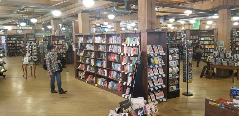 people shopping in bookstore with shelves lined with books in Denver