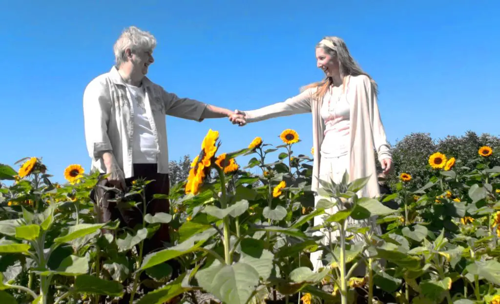 mother and daughter holding hands in a sunflower field