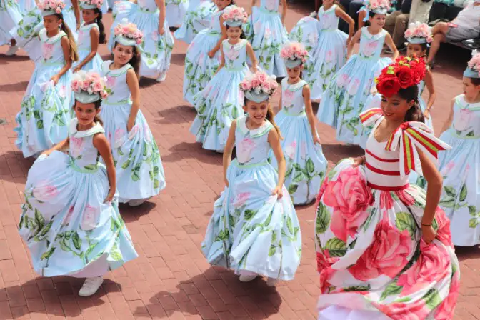 girls dancing with flowered hats at one of the most beautiful flower festivals in the world