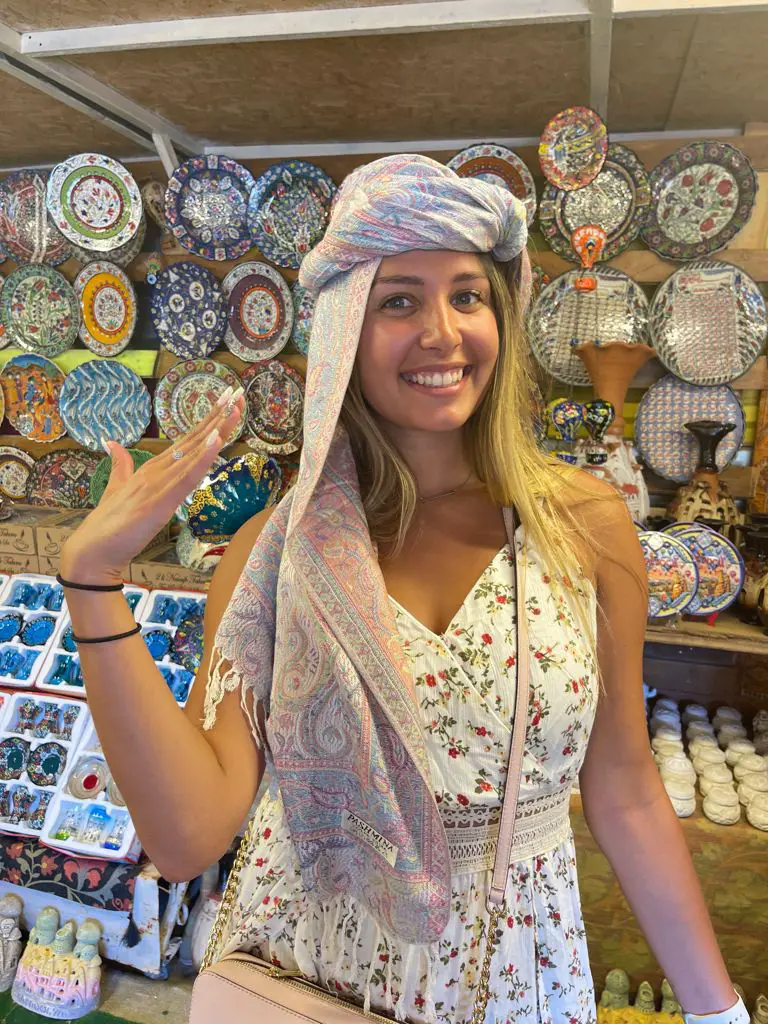 lady modeling a Pashmina head scarf souvenir of Turkey in a gift shop