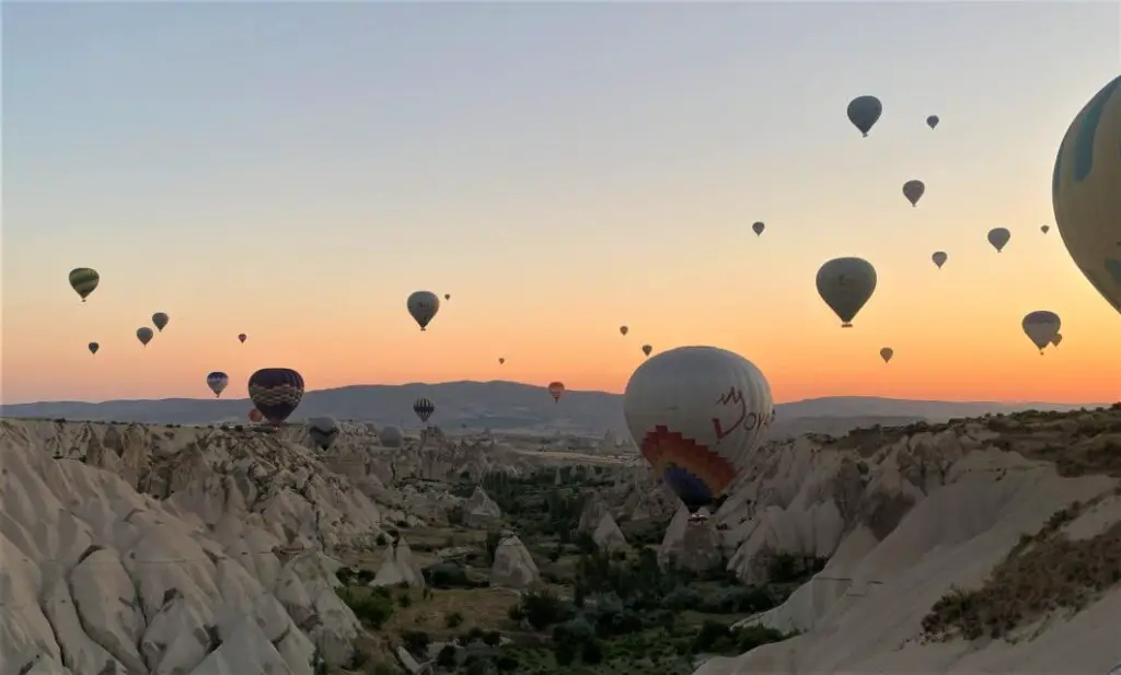 lots of hot air balloons floating throught the valley in Cappadocia Turkey