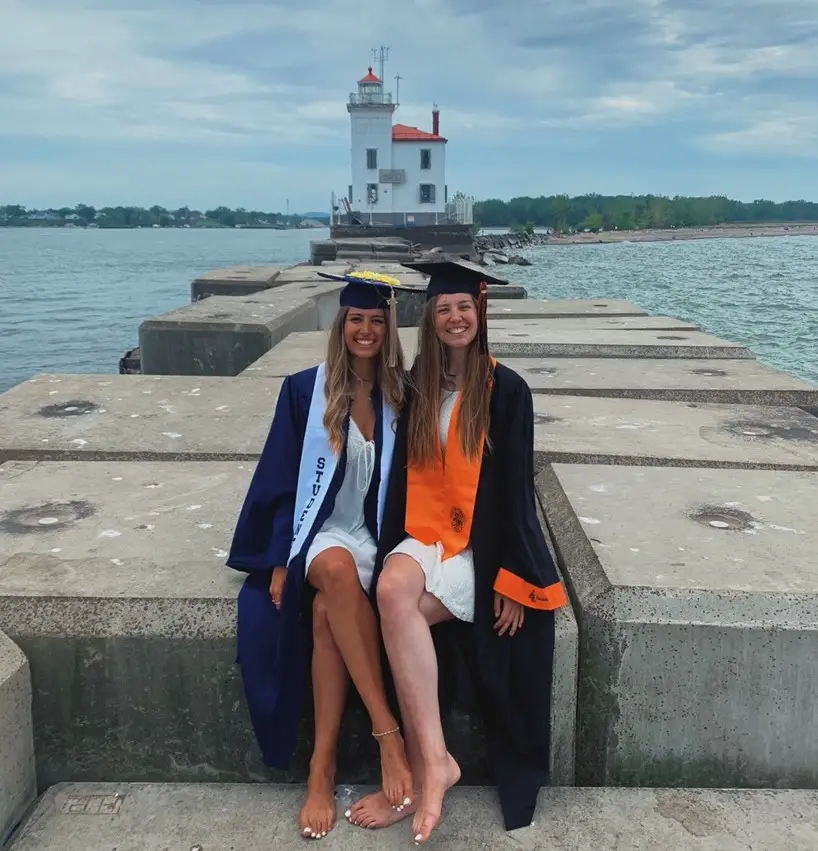 graduates pose at the lighthouse at Headlands state park beach in ohio on lake erie