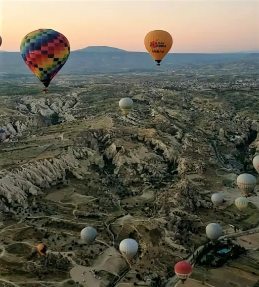 pretty Cappadocia hot air balloons in front of mountain