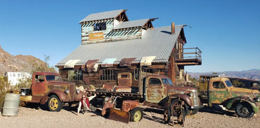 posing in the dirt with old cars and an old building for Birthday photos in Las Vegas at Nelsons Ghosttown