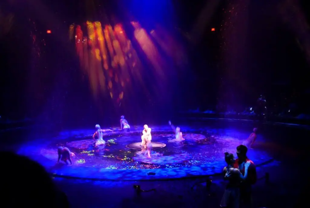 dark room with water and dancers in the middle for a las vegas show for birthday entertainment
