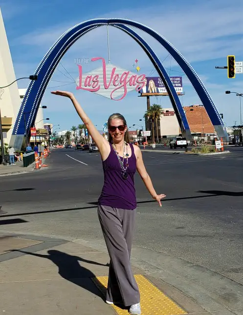 posing under the Las Vegas sign near the Stratosphere in Las Vegas