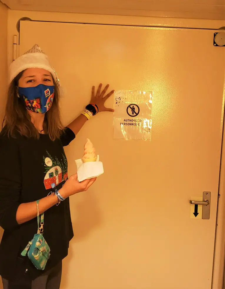 person standing in front of a locked door holdig an ice cream cone