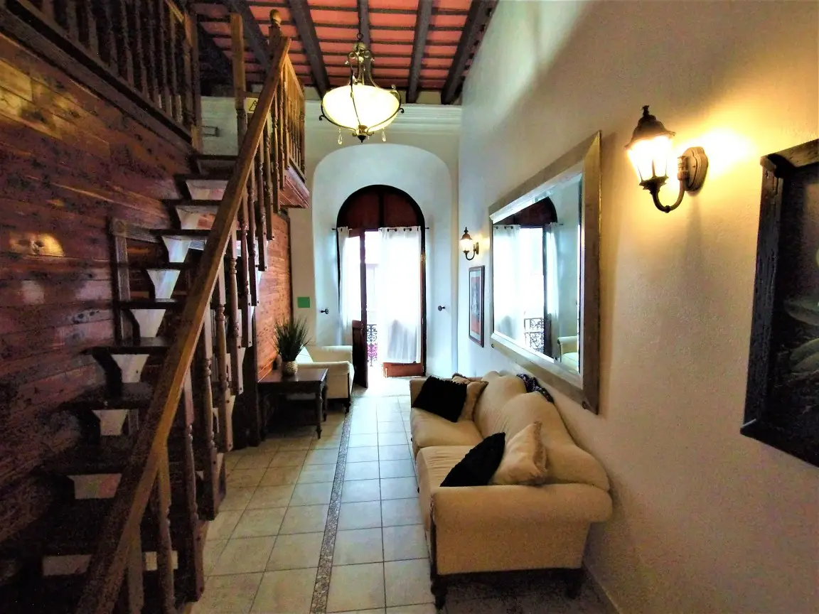 couches and stairway in a living room with an open door to a balcony in a suite hotel in old san juan puerto rico