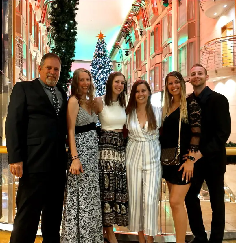 group of 6 people in front of a Christmas tree on a cruise
