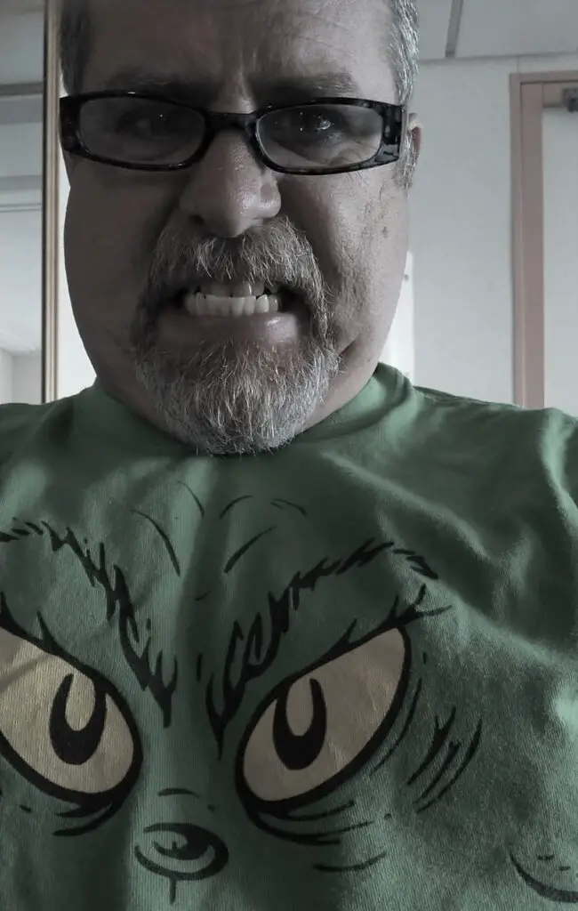 man in Grinch shirt growling at the camera