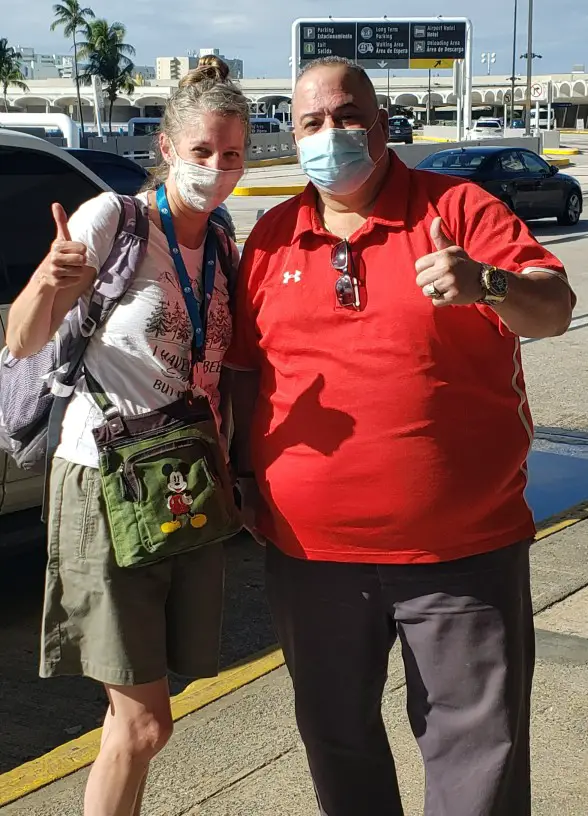 two people with thumbs up and masks at the puerto rico airport