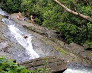 people in a natural water slide waterfall in Puerto Rico