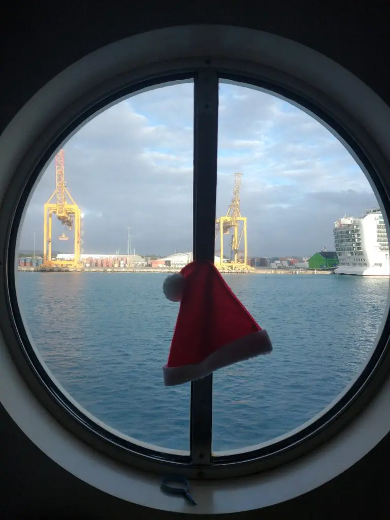 santa hat hanging on a circular window while quarantined on a cruise ship