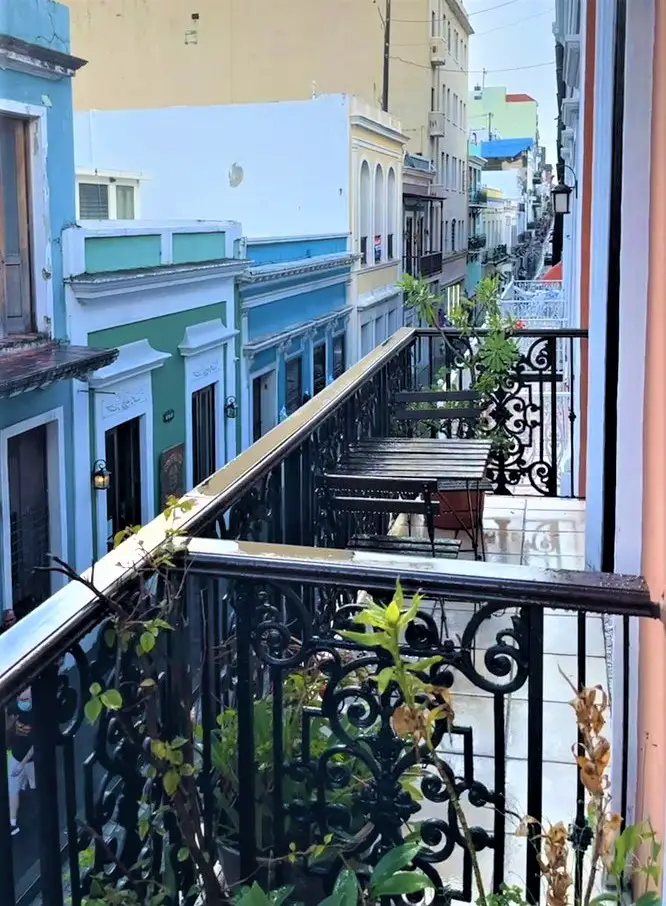 balcony view with flowers and colorful buildings in the background of old san juan puerto rico