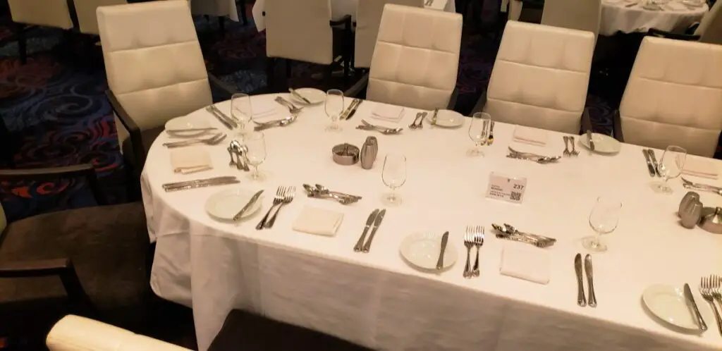 large table with white table cloth, set with dishes and silverware