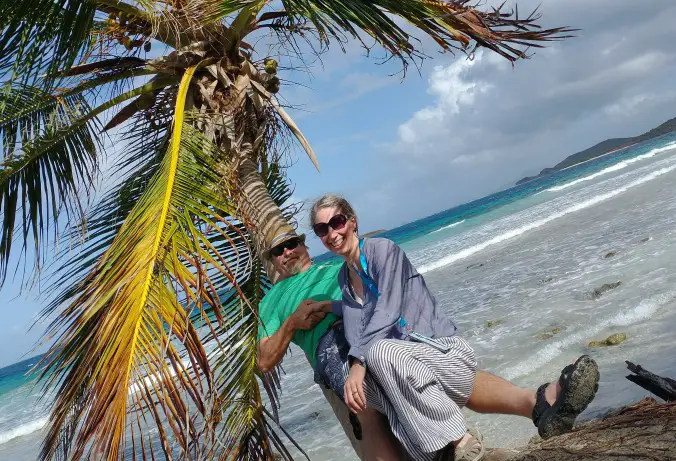 man and woman sitting on a palm tree on the beach in Culebra Puerto Rico