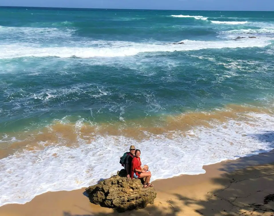 2 people sitting on a rock at a beach in San Juan on a 3-day trip to Puerto Rico