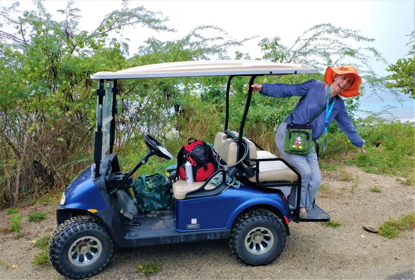 lady hanging off the back of a blue golf cart while Riding around a golf cart on Culebra for a day in puerto Rico