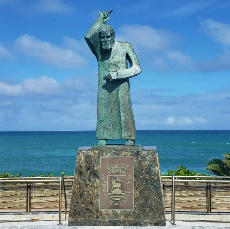 green statue in front of the water of San Juan Bautista in Puerto Rico