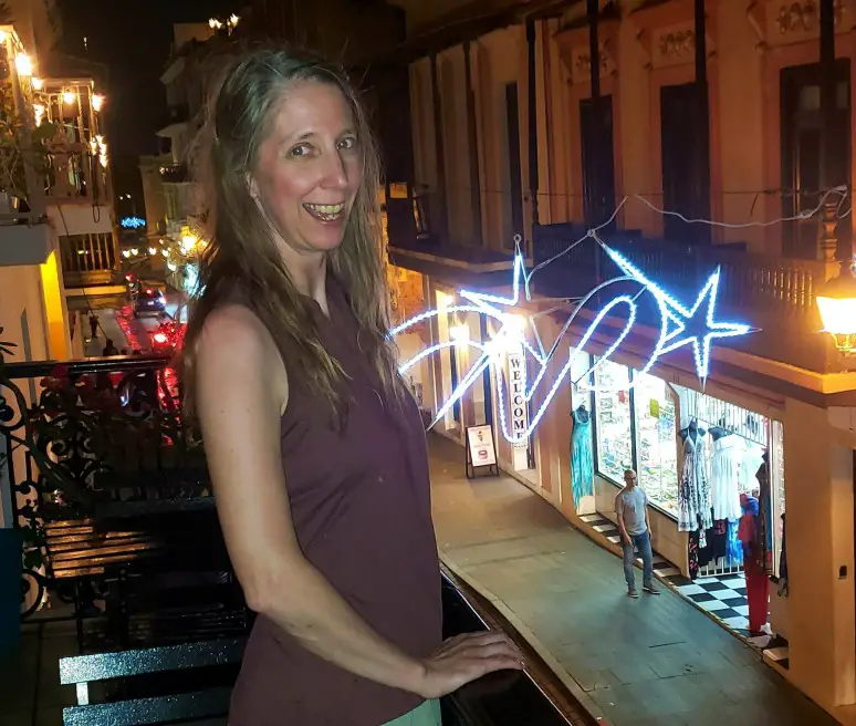 lady standing on the balcony with lights Enjoying the Puerto Rico city streets at night in san Juan