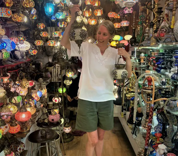 lady holding 2 turkish lamps in a colorful lamp store at the spice bazaar in istanbul
