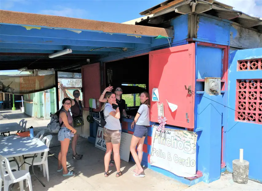 people standing in line in front of a food shack for Buying authentic Puerto Rico Food at the kiosks in Pinones